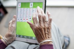 Older woman playing solitaire on a tablet